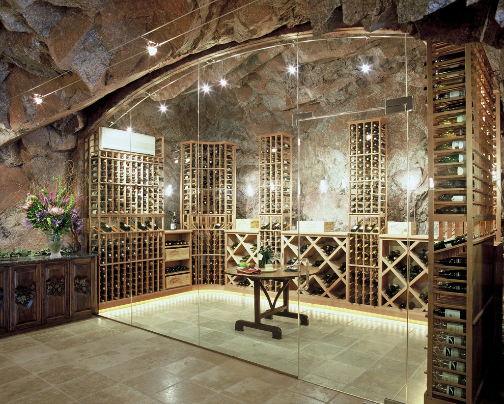 Exemple d'une cave à vin chic de taille moyenne avec un sol beige, tomettes au sol et des casiers.