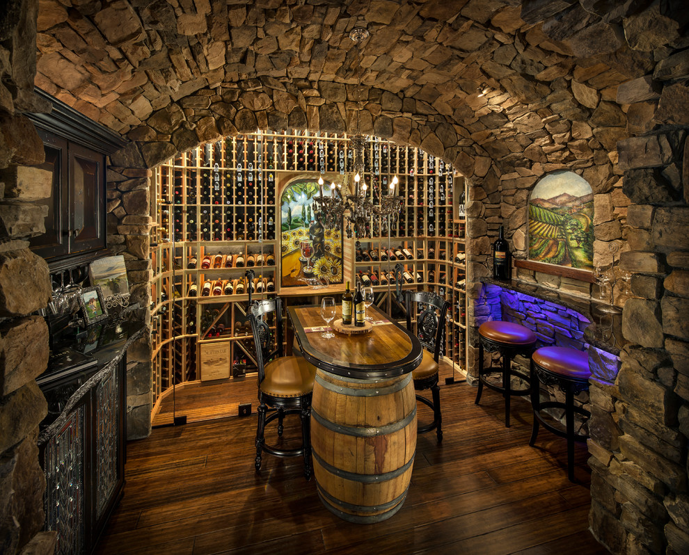 Idée de décoration pour une grande cave à vin tradition avec des casiers, parquet foncé et un sol beige.