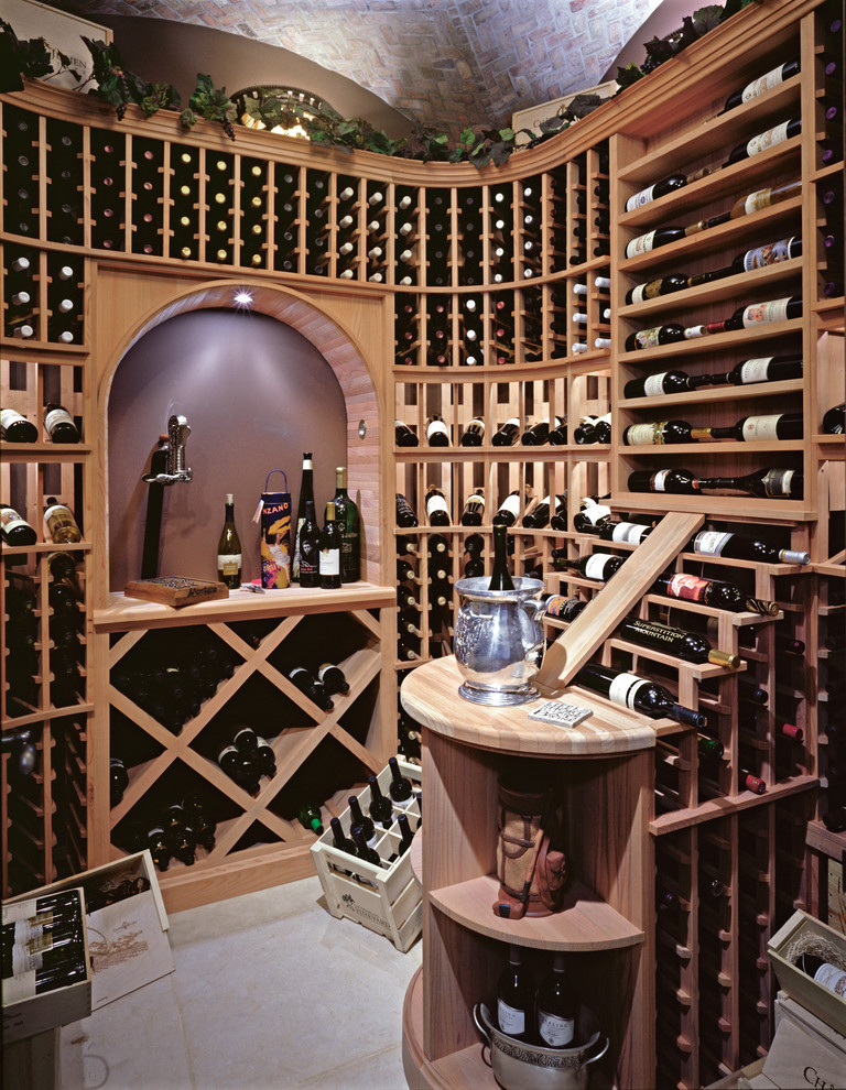 Cette image montre une grande cave à vin traditionnelle avec parquet foncé, des casiers et un sol beige.