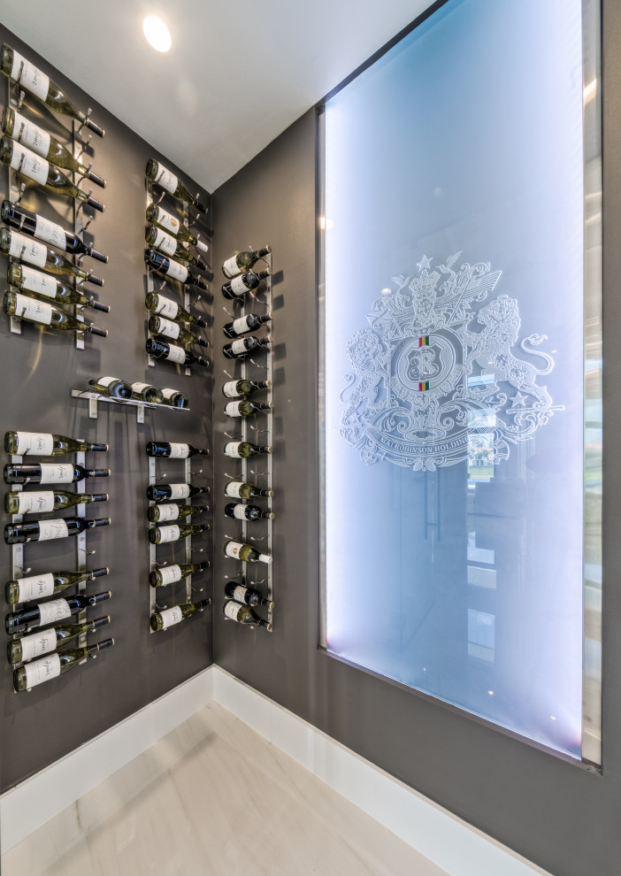 Example of a mid-sized transitional marble floor and beige floor wine cellar design in Miami with display racks