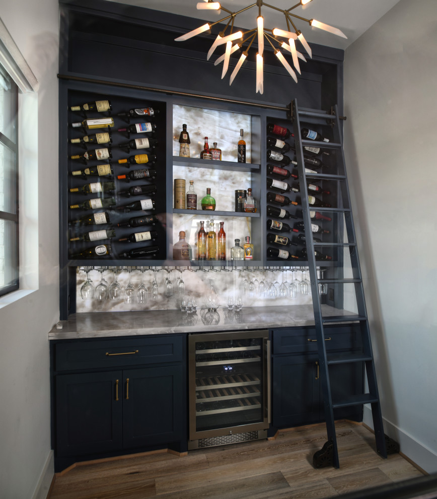 Inspiration for a mid-sized transitional medium tone wood floor and gray floor wine cellar remodel in Houston with display racks