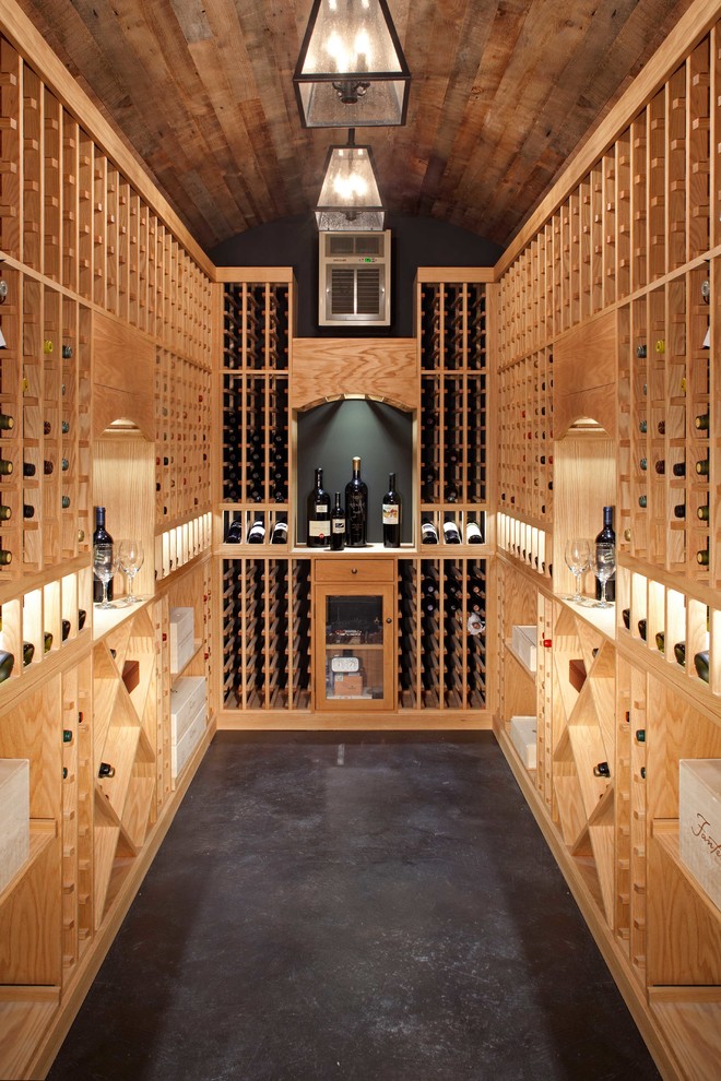 Klassisk inredning av en stor vinkällare, med vinställ med diagonal vinförvaring, betonggolv och grått golv