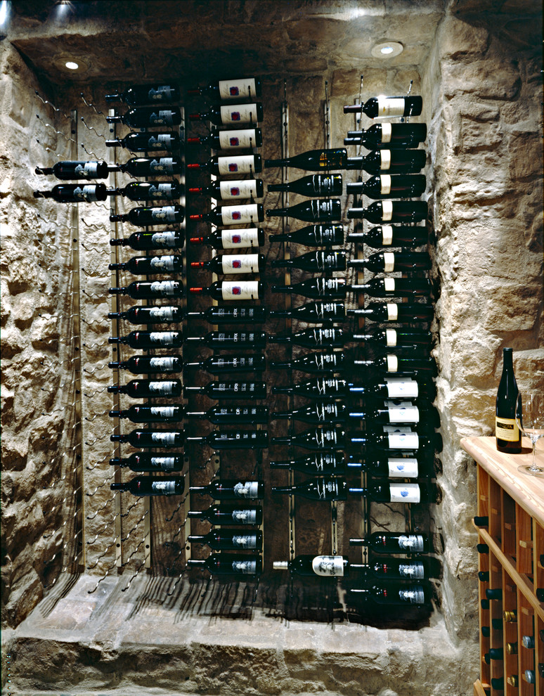Réalisation d'une cave à vin tradition de taille moyenne avec un présentoir, un sol en carrelage de porcelaine et un sol noir.