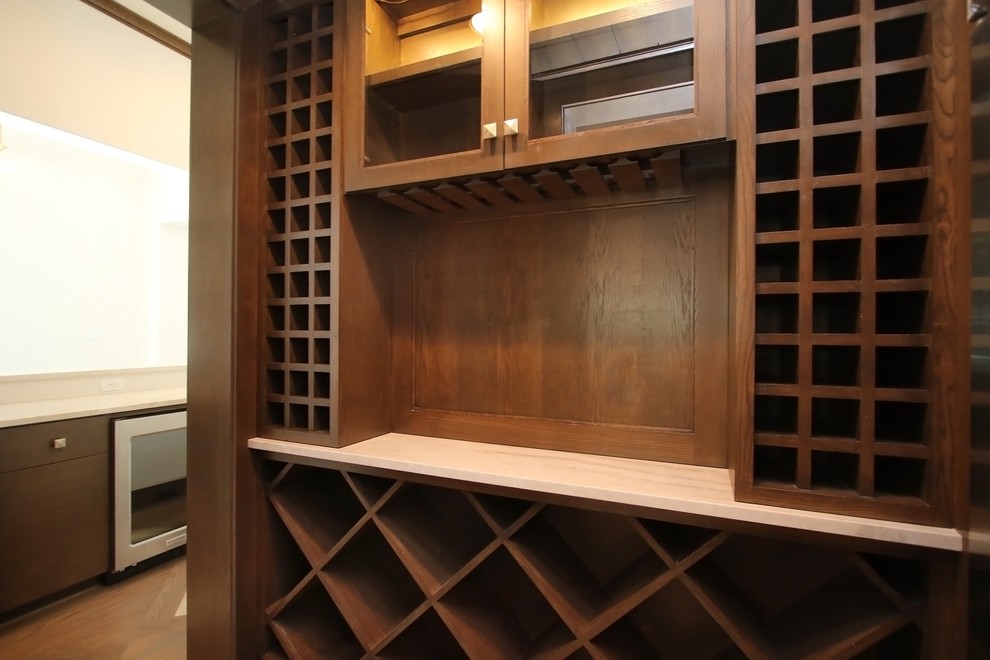 Exemple d'une cave à vin chic de taille moyenne avec un sol en bois brun et des casiers losange.