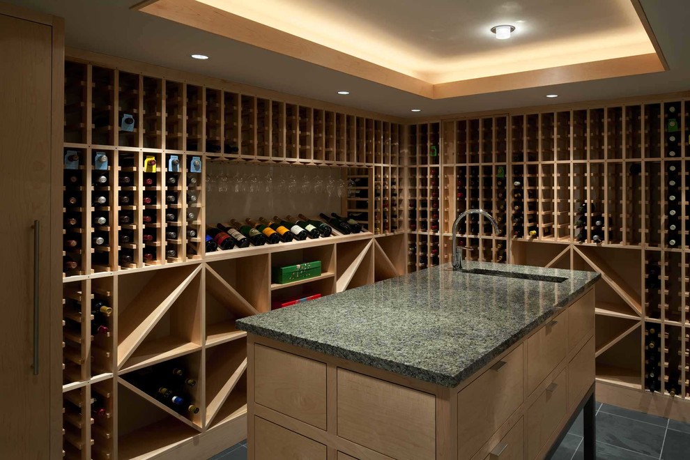 Foto på en mellanstor funkis vinkällare, med vinhyllor, skiffergolv och grått golv