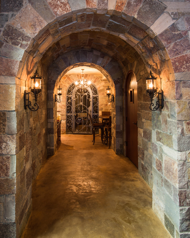 Exemple d'une grande cave à vin chic avec sol en béton ciré et un sol marron.