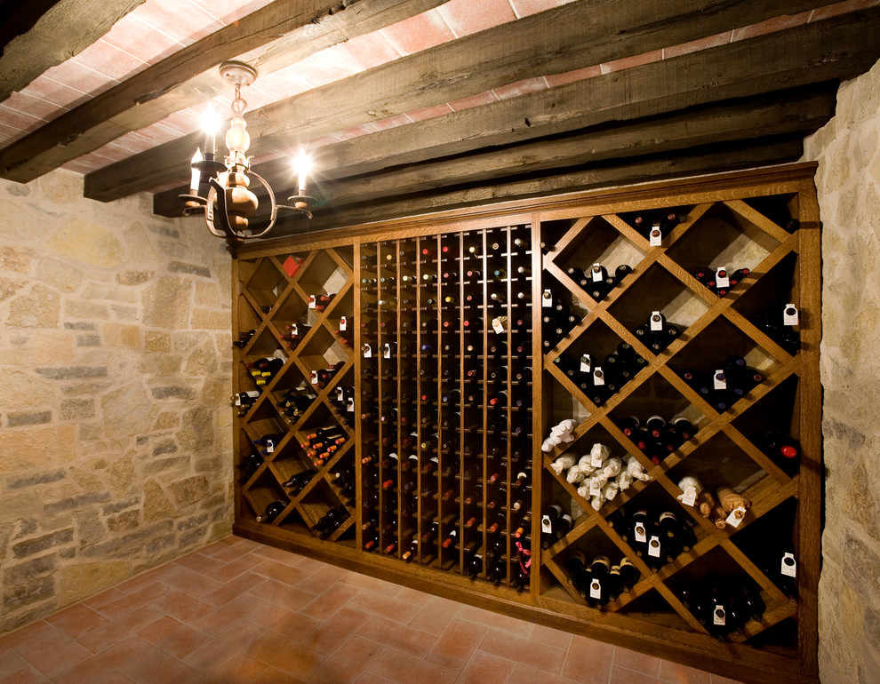 Aménagement d'une cave à vin classique de taille moyenne avec tomettes au sol et des casiers losange.