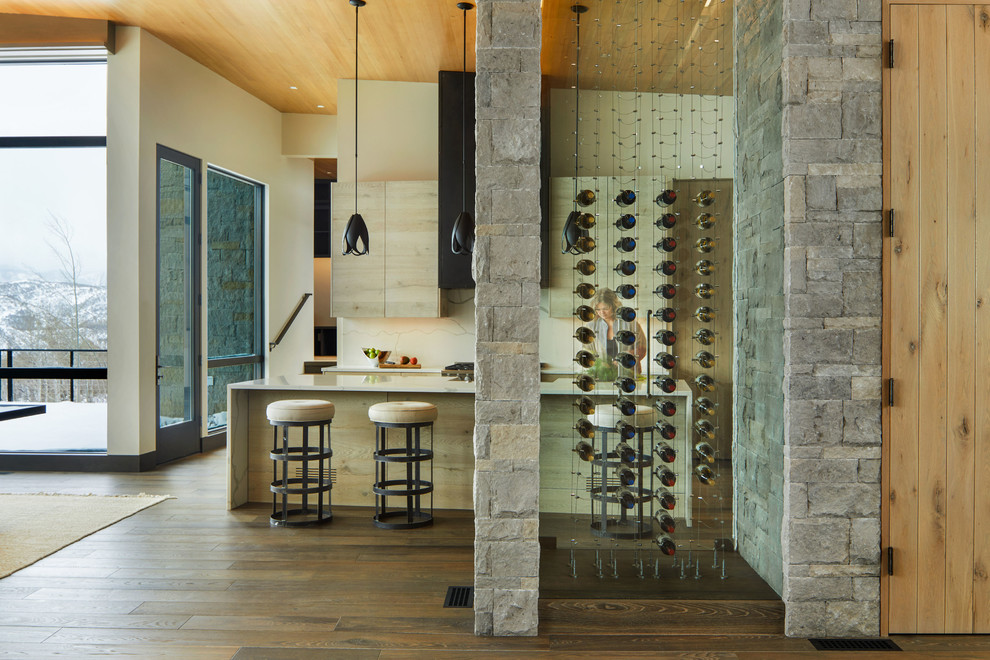 Inspiration for a mid-sized rustic medium tone wood floor and brown floor wine cellar remodel in Denver with storage racks