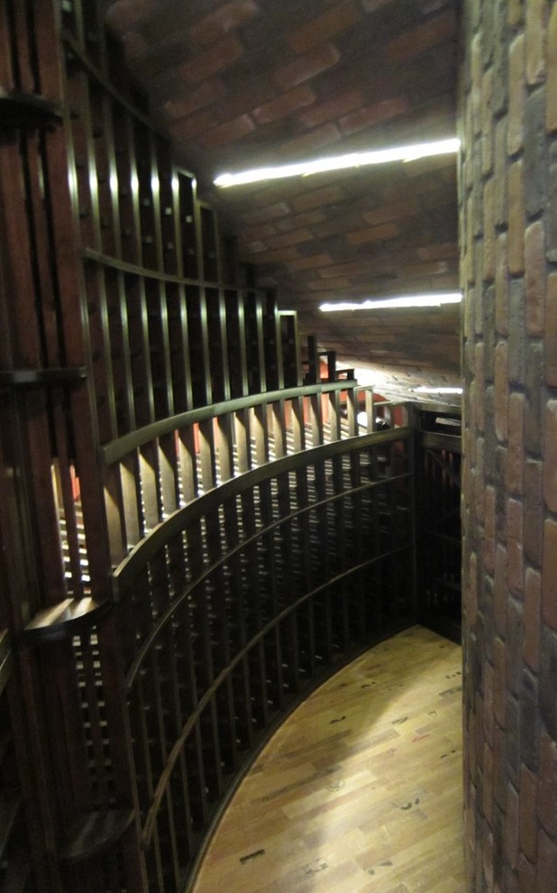 Photo of a small classic wine cellar in Los Angeles with light hardwood flooring, display racks and beige floors.