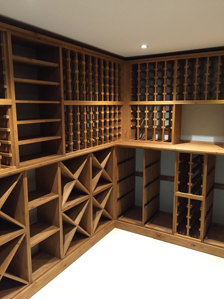Cette photo montre une grande cave à vin tendance avec des casiers, sol en béton ciré et un sol gris.