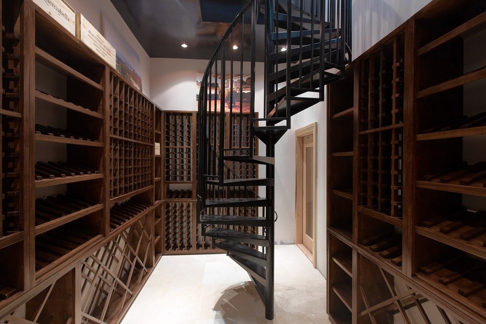 This is an example of a large traditional wine cellar in New York with marble flooring and storage racks.