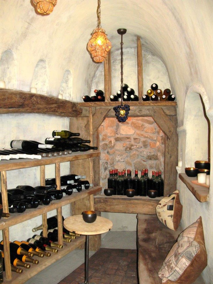 Exemple d'une grande cave à vin nature avec tomettes au sol et un présentoir.
