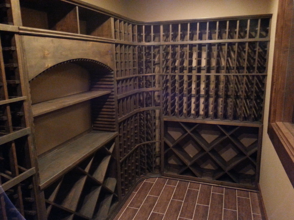 Elegant painted wood floor wine cellar photo in Austin with storage racks