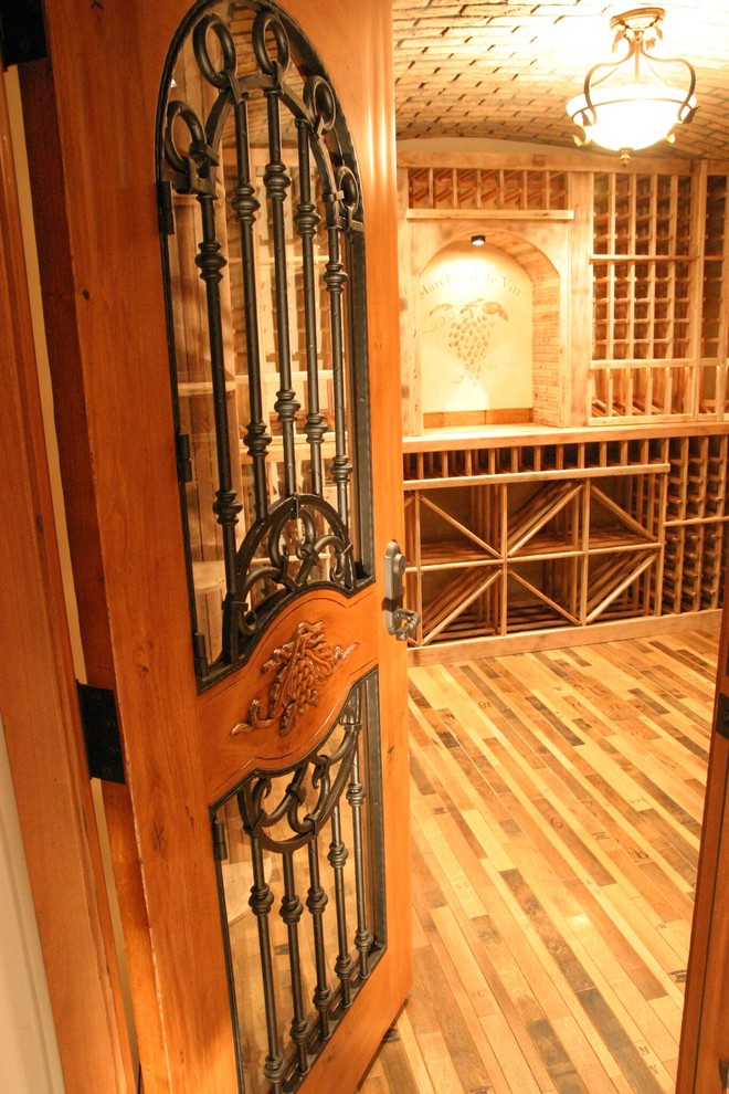Großer Klassischer Weinkeller mit dunklem Holzboden und Kammern in Orange County