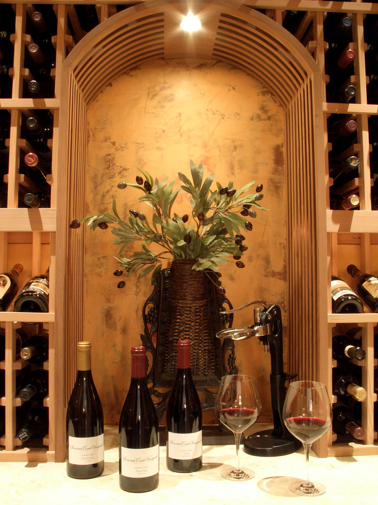 Foto på en stor medelhavsstil vinkällare, med vinhyllor och kalkstensgolv