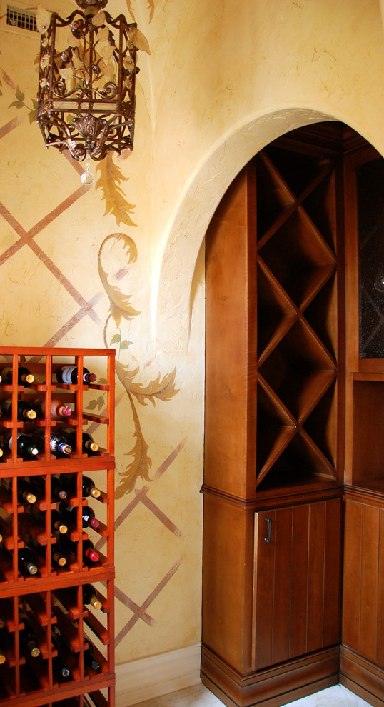 Aménagement d'une petite cave à vin méditerranéenne avec des casiers losange.