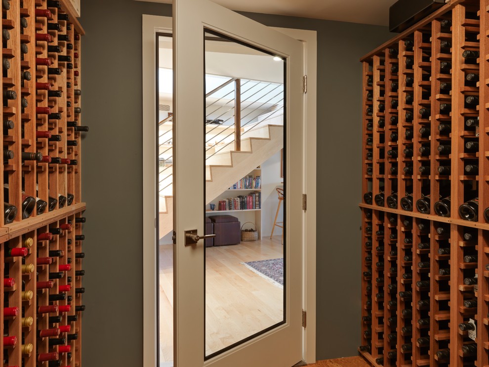 This is an example of a medium sized midcentury wine cellar in Burlington with cork flooring and storage racks.