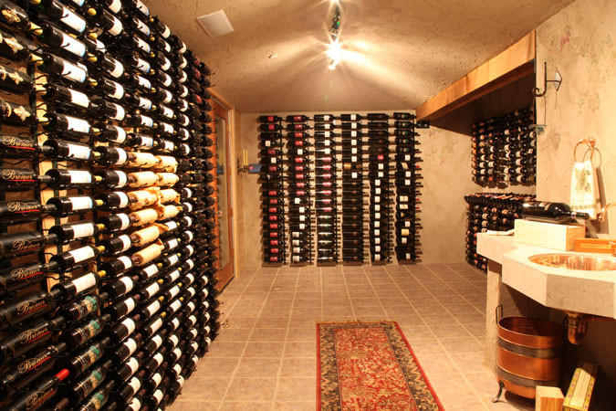 Large elegant ceramic tile wine cellar photo in Los Angeles with display racks