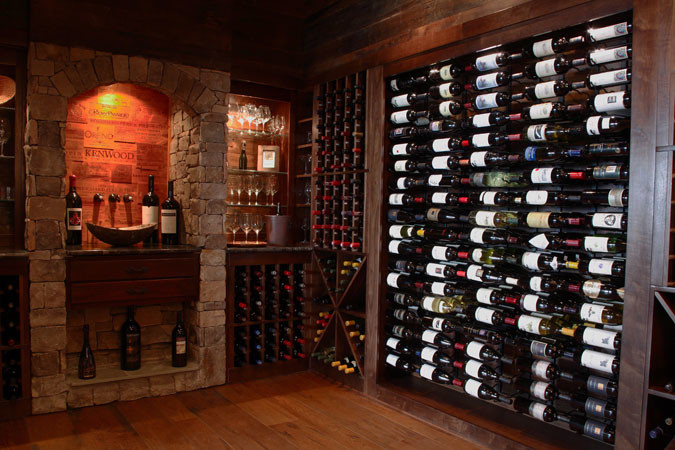 Foto de bodega clásica de tamaño medio con suelo de madera oscura y botelleros