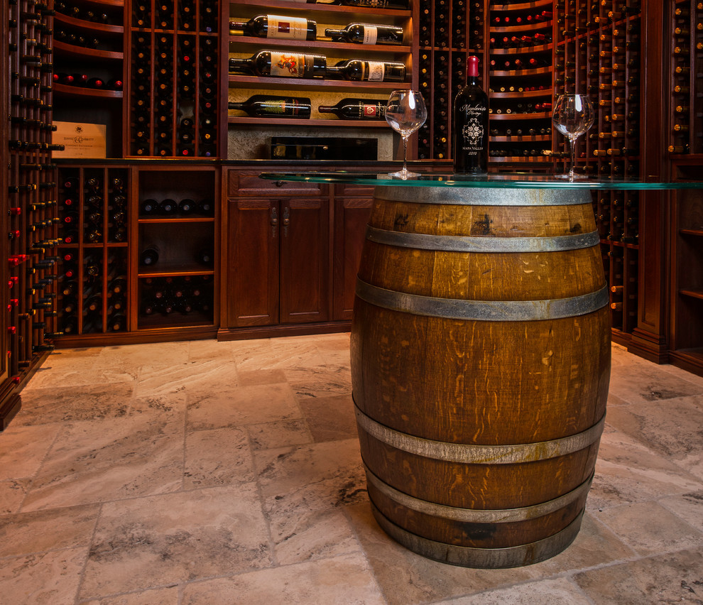 Aménagement d'une cave à vin classique de taille moyenne avec un sol en calcaire, des casiers et un sol beige.