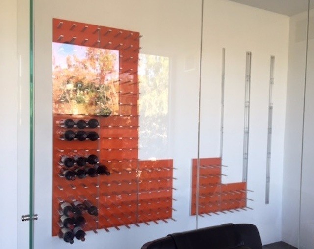 This is an example of a large modern wine cellar in San Francisco with display racks.
