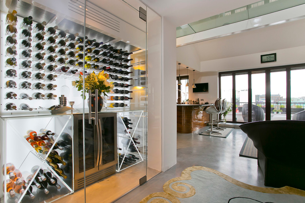 Contemporary wine cellar in London with concrete flooring.