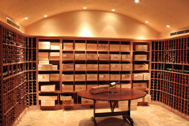 Inspiration for a large traditional wine cellar in Houston with travertine flooring, storage racks and beige floors.