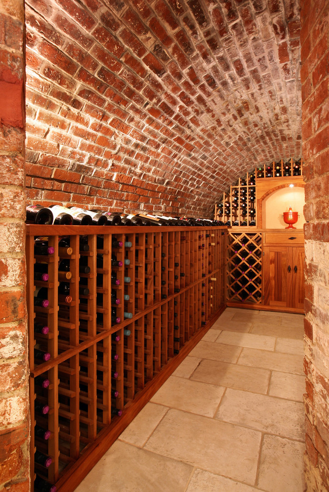 Rustic wine cellar in Boston with travertine flooring and storage racks.