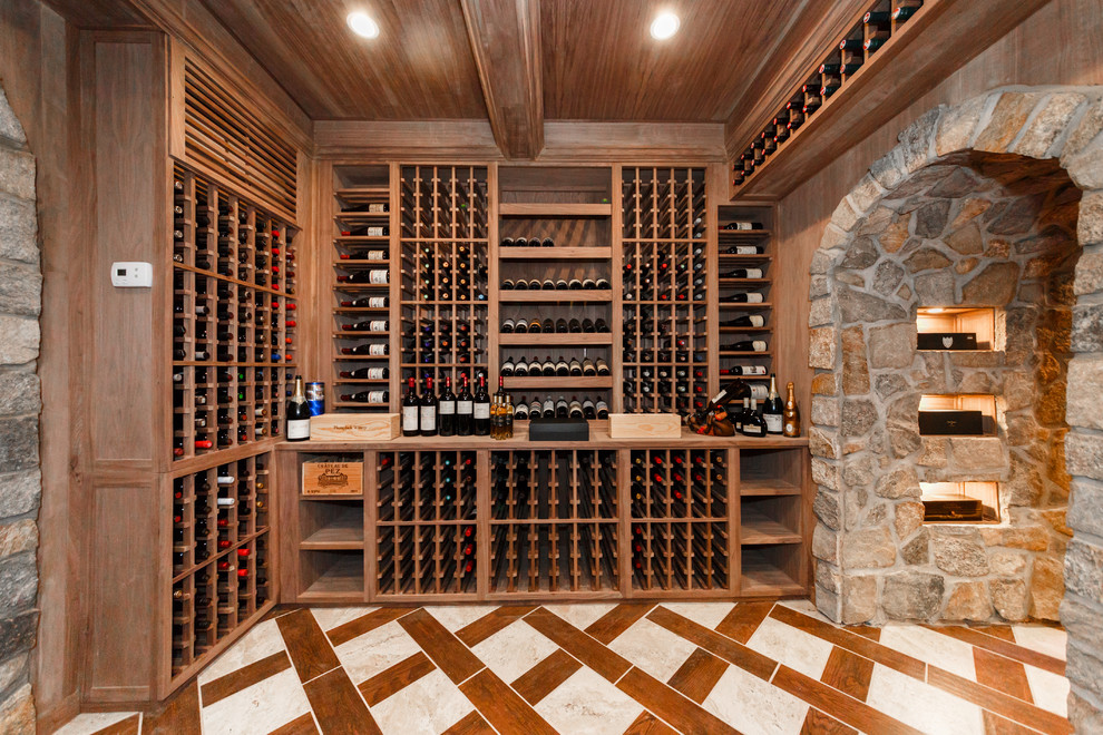 Exemple d'une très grande cave à vin montagne avec un sol en carrelage de porcelaine, un présentoir et un sol marron.