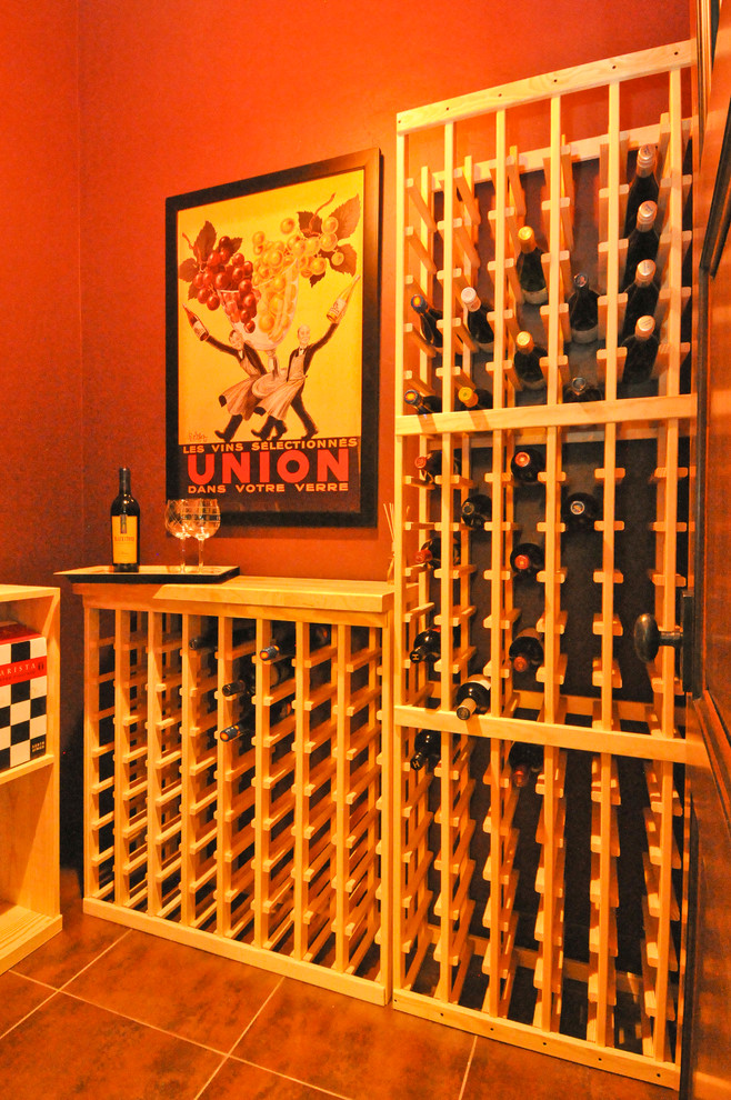 Small rustic wine cellar in Denver with ceramic flooring, storage racks and brown floors.