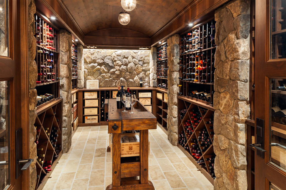 Example of a large transitional travertine floor wine cellar design in Boston with storage racks