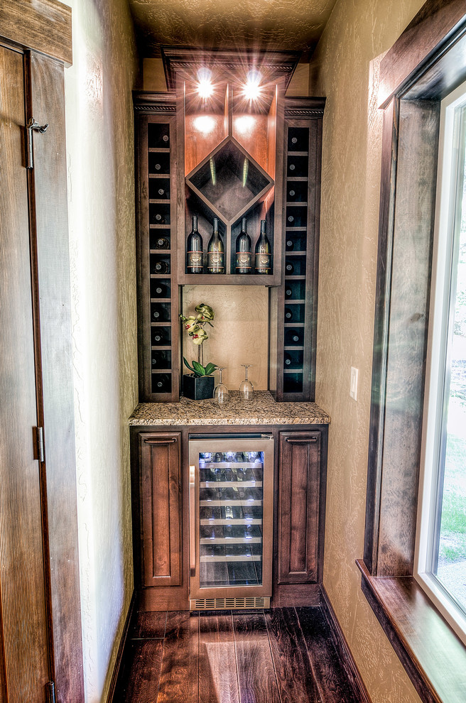 Cette image montre une petite cave à vin craftsman avec parquet foncé et des casiers.