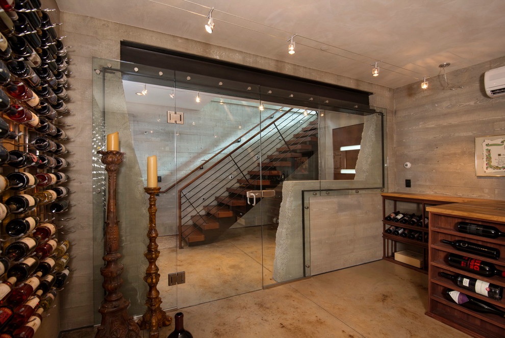 Idée de décoration pour une cave à vin design avec sol en béton ciré et des casiers.
