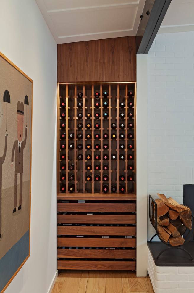 Kleiner Moderner Weinkeller mit braunem Holzboden und Kammern in New York