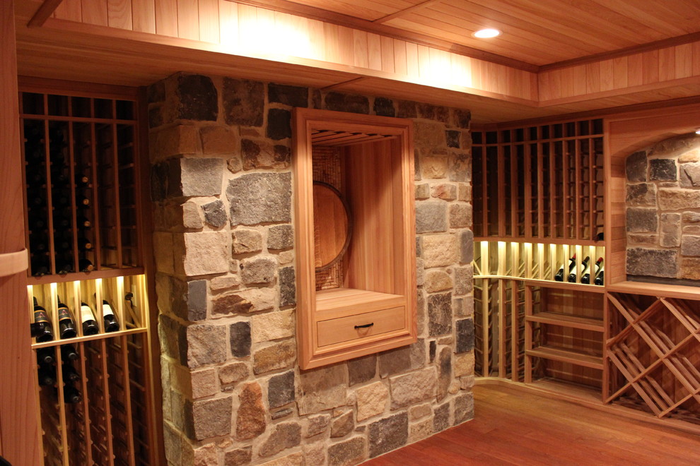 Classic wine cellar in Philadelphia with medium hardwood flooring and display racks.