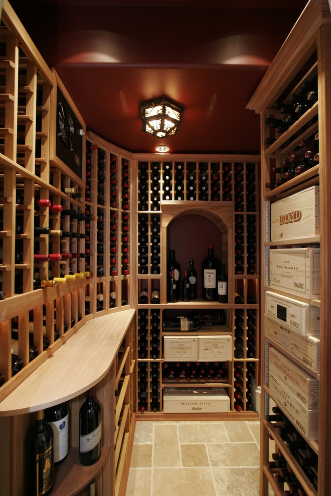 Example of a huge tuscan travertine floor wine cellar design in San Francisco with storage racks