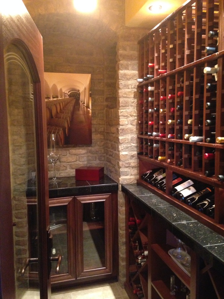 Wine cellar - small mediterranean ceramic tile and beige floor wine cellar idea in Other with storage racks