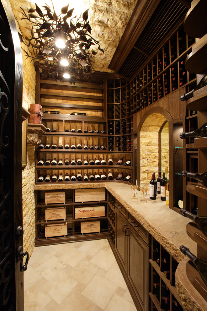 Example of a mid-sized classic travertine floor and beige floor wine cellar design in San Diego with display racks