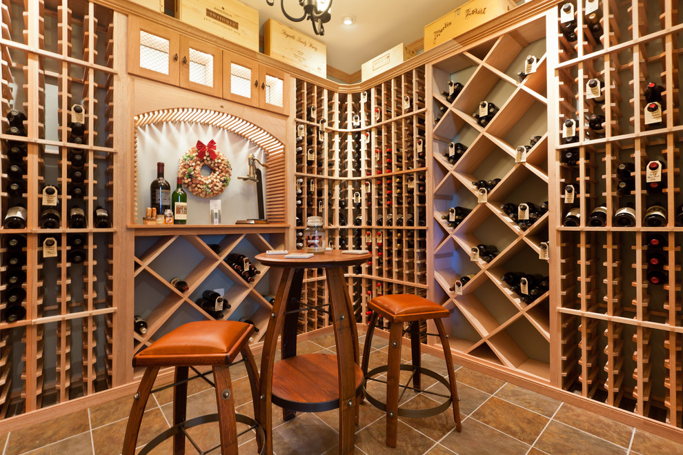 Réalisation d'une cave à vin craftsman de taille moyenne avec un sol en carrelage de porcelaine et des casiers losange.