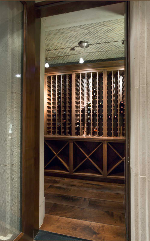 Cette image montre une grande cave à vin minimaliste avec un sol en bois brun et des casiers.
