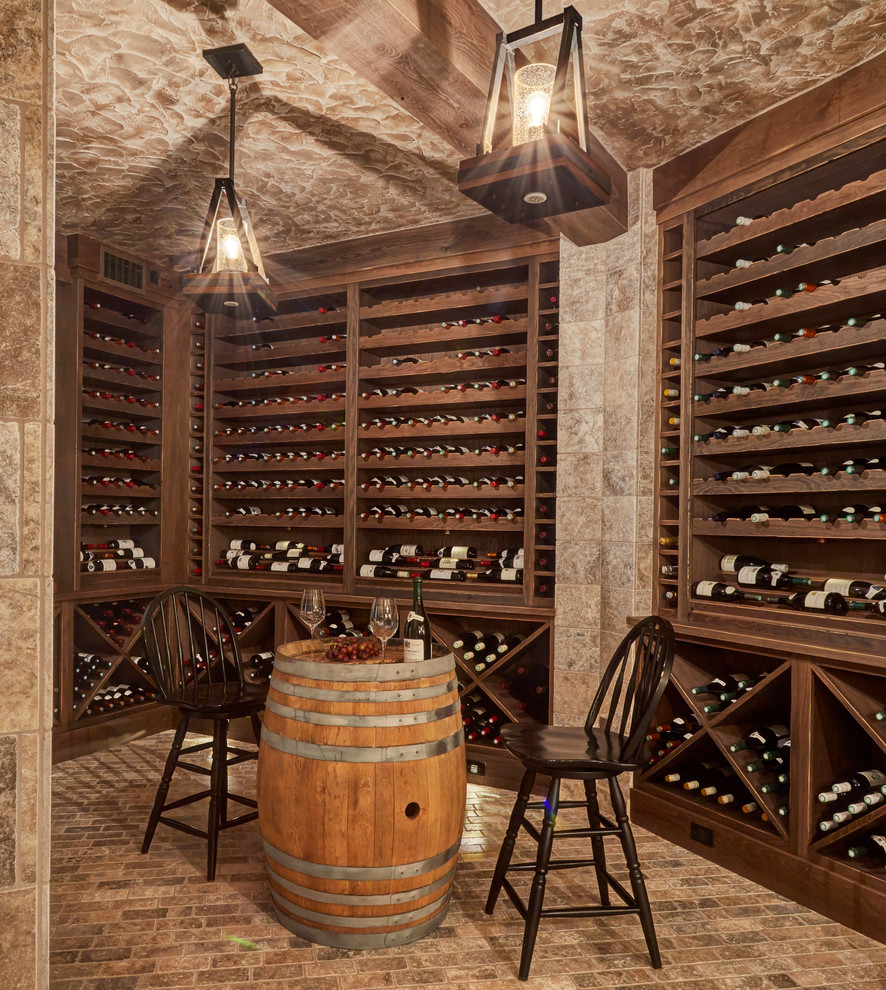 Réalisation d'une cave à vin méditerranéenne avec un sol en brique, des casiers et un sol marron.