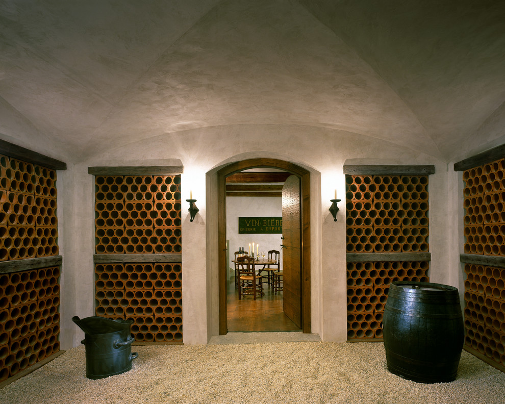 Cette image montre une très grande cave à vin rustique avec des casiers.