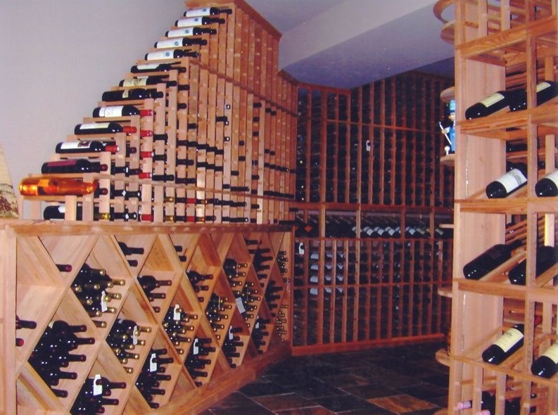 На фото: огромный винный погреб в стиле неоклассика (современная классика) с витринами, полом из керамической плитки и разноцветным полом с