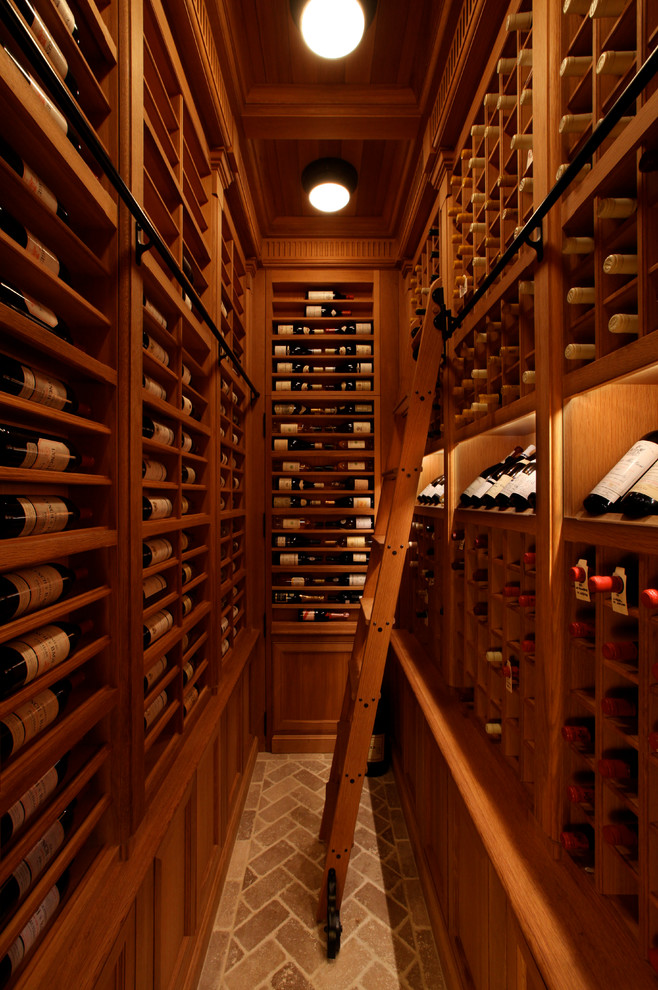 Cette image montre une grande cave à vin traditionnelle avec des casiers et un sol en brique.