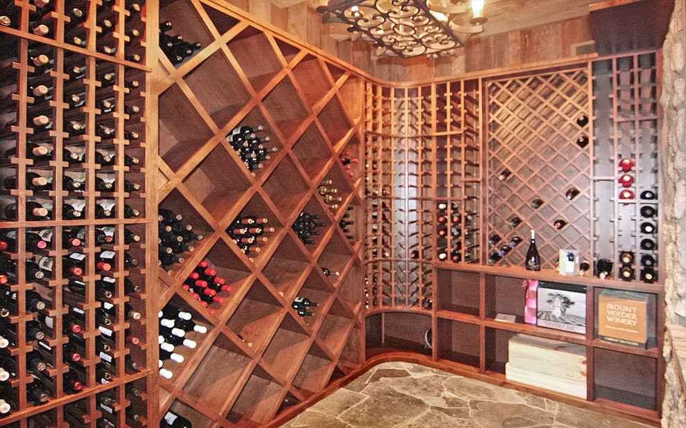 Mid-sized mountain style slate floor wine cellar photo in Other with storage racks