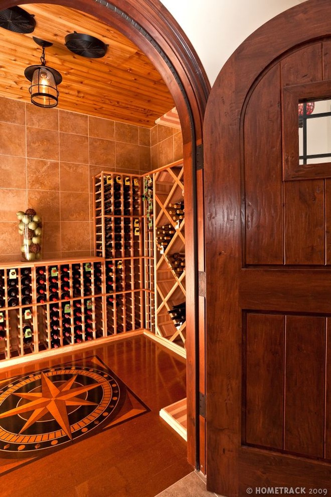 Bild på en mellanstor rustik vinkällare, med mörkt trägolv, vinställ med diagonal vinförvaring och brunt golv
