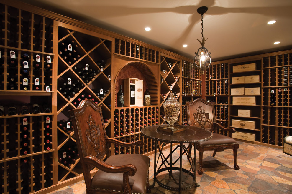 Expansive classic wine cellar in Other with limestone flooring and storage racks.