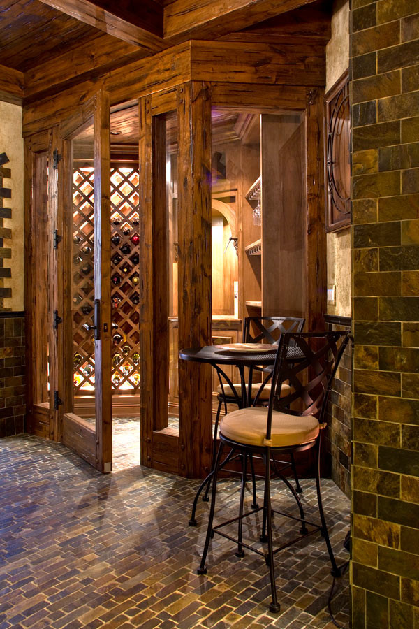 Klassisk inredning av en mellanstor vinkällare, med vinställ med diagonal vinförvaring och brunt golv