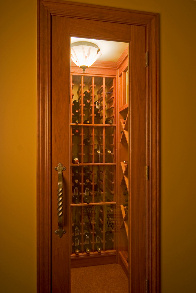 This is an example of a small traditional wine cellar in Minneapolis with cork flooring and storage racks.