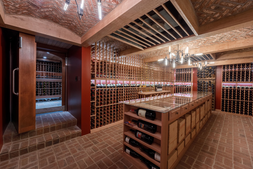 Photo of a large traditional wine cellar in Other with brick flooring, storage racks and red floors.